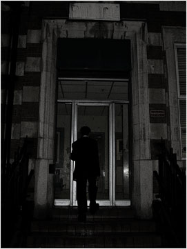 It is raining and late into the night.. A mysterious, haggard man in a suit enters a Police Station