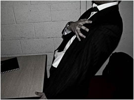 He tries to stand up clutching his chest, but struggles and ends up falling to the ground